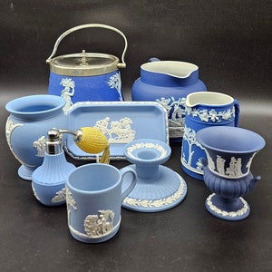 May include: A collection of blue and white ceramic items, including a teapot, creamer, sugar bowl, and a small vase. The items are decorated with white floral designs and are all in the same style.