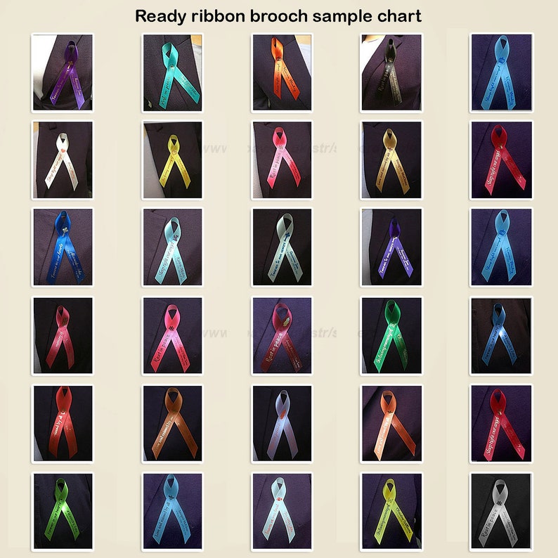 May include: A sample chart of ready ribbon brooches. The brooches are in various colors, including purple, teal, orange, and red. Each ribbon has text on it. The brooches are pinned to a dark fabric.