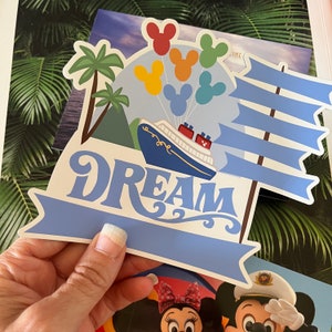 May include: A blue and white Disney cruise ship with the word "DREAM" in a whimsical font. The ship is surrounded by colorful Mickey Mouse heads and a blue and white sail.