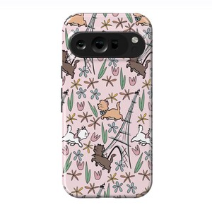 May include: A phone case with a pink background. It has a repeating pattern of cartoon cats, flowers, and the Eiffel Tower. The cats are brown, white, and tan. The flowers are pink, blue, and yellow. The case is designed for a phone.