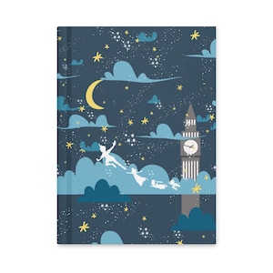 May include: A hardcover journal with a whimsical night sky design. The cover features a dark blue background with clouds, stars, and a crescent moon. Silhouettes of characters fly near a clock tower. The journal is a perfect gift for writers.