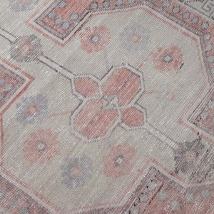 Puede incluir: Una alfombra vintage con un patr&oacute;n descolorido en rosa y gris. La alfombra tiene un dise&ntilde;o tradicional con detalles intrincados.