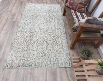 May include: A light blue and white patterned rug with a floral design. The rug is laid out on a wooden floor.