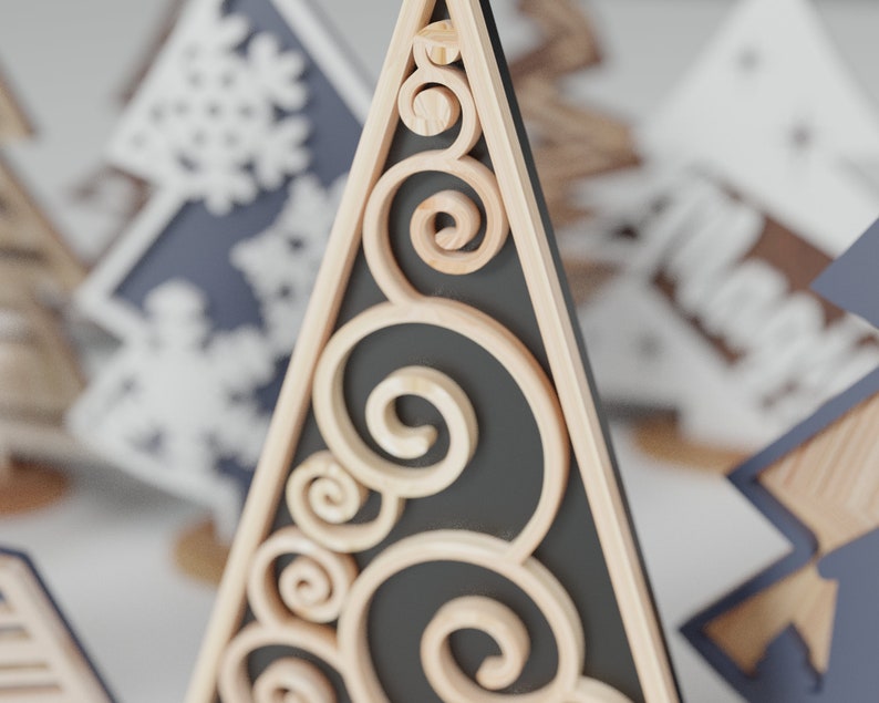 May include: A wooden Christmas tree ornament with a black background and intricate scrollwork details.