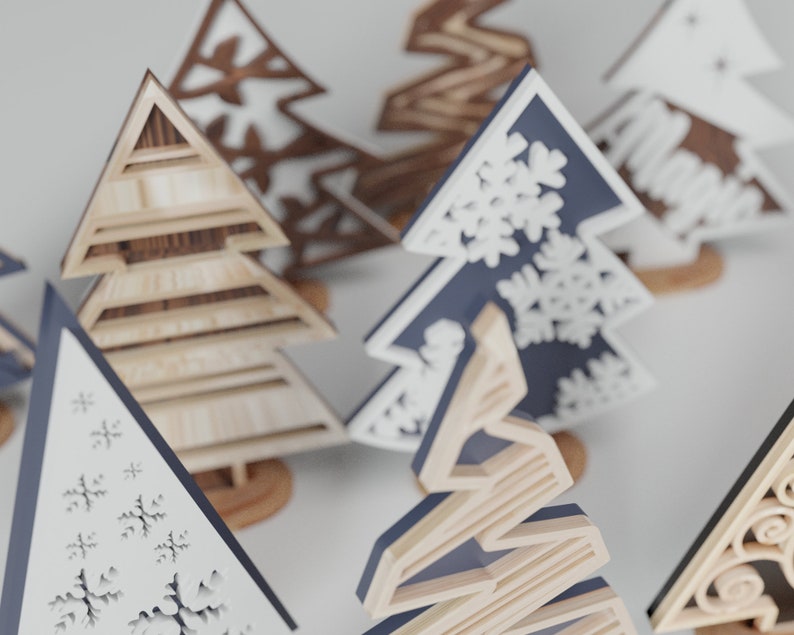 May include: Assortment of wooden Christmas tree ornaments in various styles and colors. Some trees are decorated with snowflakes, while others have a more rustic look.