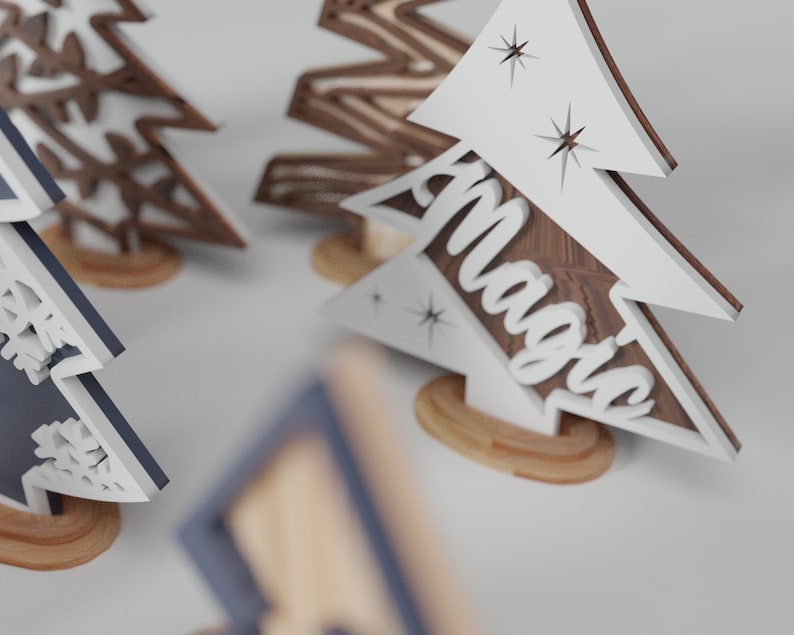 May include: Three wooden Christmas tree ornaments with different designs. One is brown with a snowflake pattern, one is blue with a snowflake pattern, and one is white with the word "Magic" on it.
