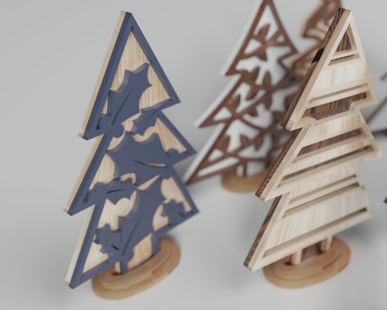 May include: Three wooden Christmas tree ornaments. One is painted blue with holly leaves, one is white with a snowflake design, and one is natural wood with a striped pattern.