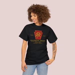 A young woman in her 20's posing, wearing the black Pennsylvania Railroad train t-shirt