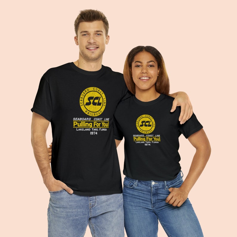 happy young couple wearing Black Seaboard Coast Line Railroad shirts, looking at us.