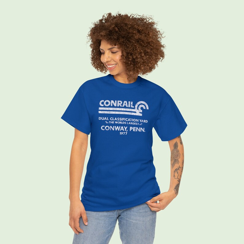 Happy young woman wearing Conrail Royal Blue CR shirt, a stylish train enthusiast gift