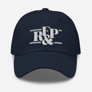 May include: A navy blue baseball cap with a white embroidered logo that says "R&P" with a line above and below the letters.