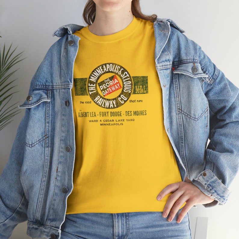 Lifestyle image of woman wearing train t-shirt with denim jacket, facing left, Gold Minneapolis & St. Louis Railway logo