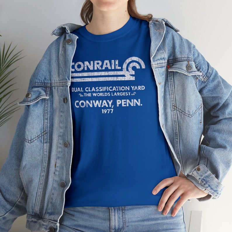 Woman wearing Conrail Royal Blue CR shirt with denim jacket, a trendy railroad shirt for a stylish look