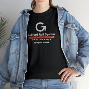 Lifestyle: Woman in denim jacket facing left, wearing Black Springfield Terminal Railway T-Shirt
