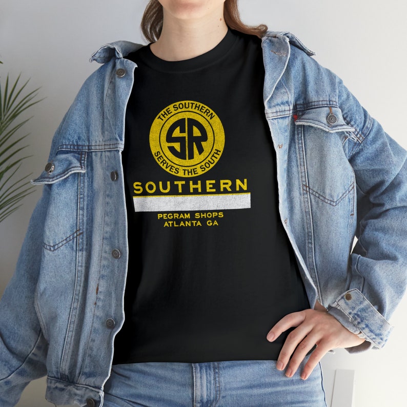Woman in denim jacket over green Southern Railway shirt, vintage railroad style.