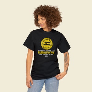 Happy young woman wearing Black Seaboard Coast Line Railroad shirt, looking left.