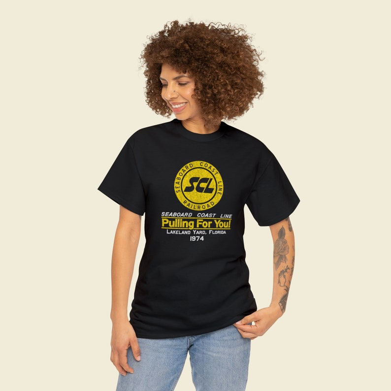 Happy young woman wearing Black Seaboard Coast Line Railroad shirt, looking left.