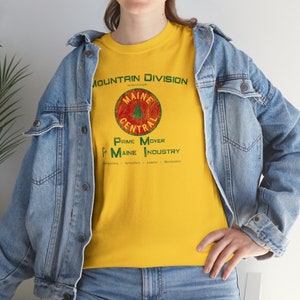 Woman wearing Yellow or Green Maine Central Railroad t-shirt with denim jacket, facing left