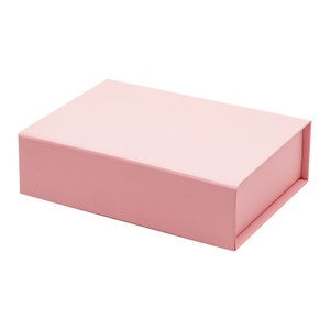 May include: A light pink rectangular box with a hinged lid. The box is made of cardboard and has a smooth finish.