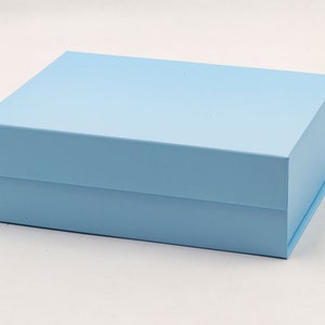 May include: A light blue gift box with a magnetic closure. The box is made of sturdy cardboard and has a smooth finish.