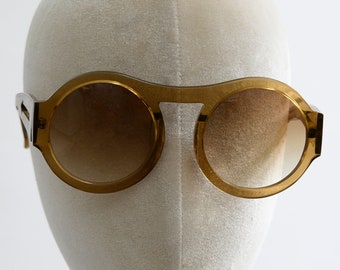 Original vintage steampunk 1960s sunglasses from Italy. Oversized brown frames with arrows on the side. Palm Royale.