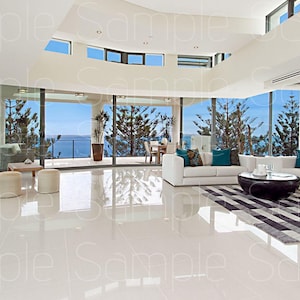 以下が含まれることがあります： 白いコーナーソファにターコイズブルーのクッションが置かれ、大きな窓から海を見渡せるモダンなリビングルームに置かれています。白のタイル張りの床には、黒と白のストライプの敷物が敷かれています。