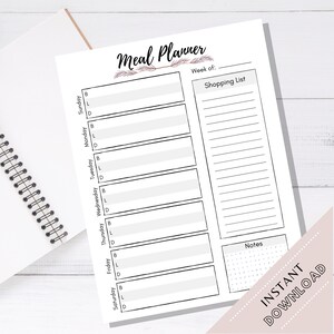 May include: A white meal planner with a black spiral binding. The planner includes sections for each day of the week, a shopping list, and notes. The words "Meal Planner", "Shopping List", "Notes", and "Instant Download" are visible.