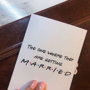 Cartão comemorativo inspirado em programa de TV “Amigos” onde eles vão se casar