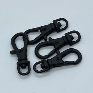 Può includere: Quattro chiusure girevoli o ganci in metallo nero. Sono perfetti per attaccare a borse, portachiavi o altri oggetti.