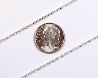 May include: A silver chain necklace next to a US dime coin for size comparison. The chain is delicate and has a cable link style.
