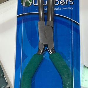 May include: Green handled pliers with a silver metal head, packaged on a blue background with the text "Wubbers Make Jewelry".