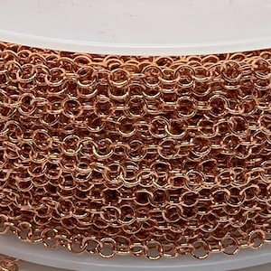 May include: A spool of rose gold chain, perfect for jewelry making. The chain is made of small, linked circles.