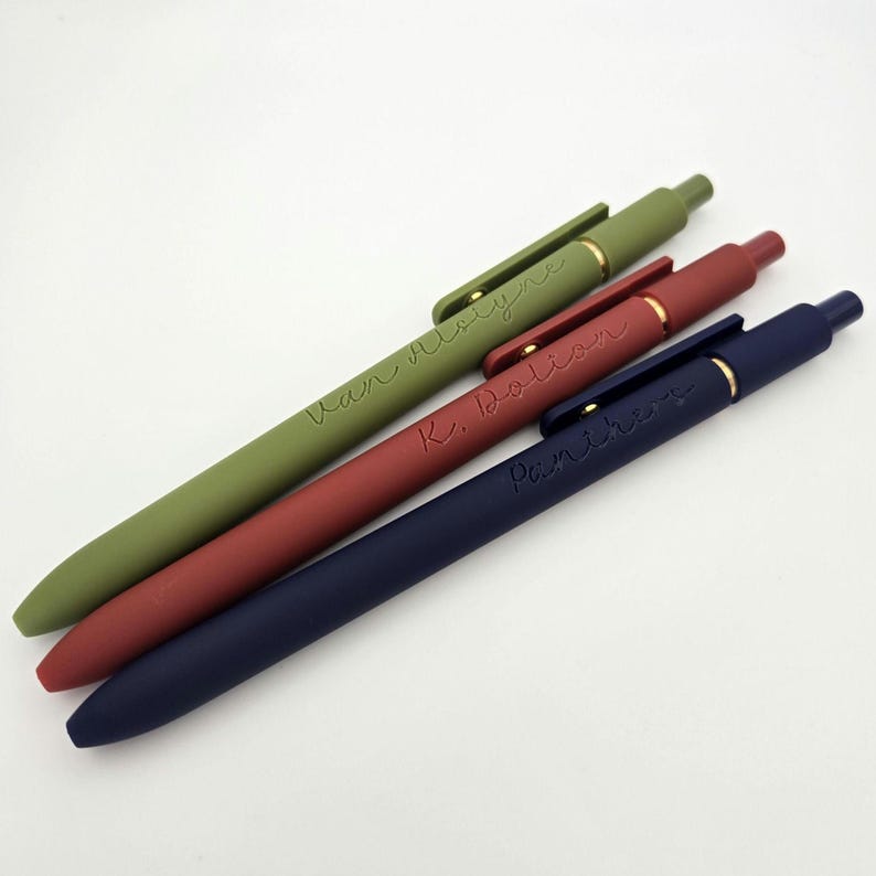 May include: Three personalized pens with different colored bodies: green, red, and blue. The pens have gold accents and are engraved with the names "Van Uyvre", "K. Dolison", and "Panicheva".