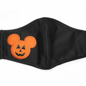 May include: Black face mask with an orange embroidered pumpkin-shaped Mickey Mouse head.