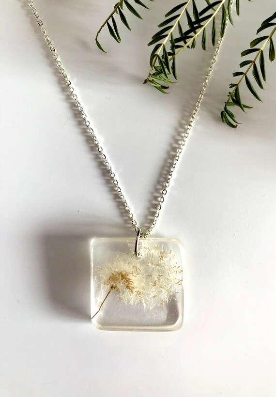 Delicate blue resin pendant with real dandelion seeds: