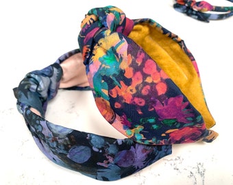 May include: Two floral patterned headbands with a knotted design. The headband on top has a mustard yellow lining.
