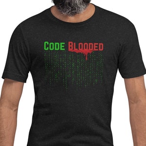 Könnte beinhalten: Ein schwarzes T-Shirt mit einer grünen und roten Grafik, auf der "CODE BLOODED" mit einem tropfenden roten Effekt steht. Die Grafik ist eine stilisierte Darstellung von Computercode.