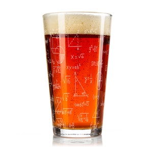 May include: A clear glass pint glass with a brown liquid inside. The glass is printed with white mathematical equations and formulas.