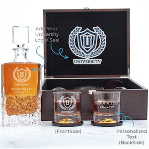 May include: A personalized whiskey decanter set with a wooden box. The set includes a decanter, two glasses, and a wooden box with a university logo. The decanter and glasses are engraved with the university logo and personalized text.