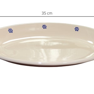 May include: A cream-coloured oval serving platter with a blue floral design. The platter measures 35 cm in length.