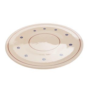 May include: A round, cream-colored ceramic plate with a dark red rim and a dark red circle in the center. The plate is decorated with small blue floral designs evenly spaced around the rim and the center circle. The plate is a simple, elegant design.
