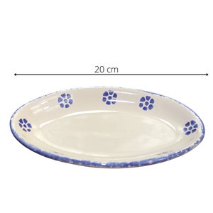 Könnte beinhalten: Eine weiße ovale Servierplatte mit blauem Rand und blauen Blumenmustern. Die Platte ist 20 cm lang.