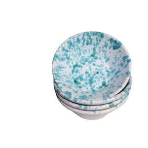 May include: Stack of four white ceramic bowls with a green speckled pattern.