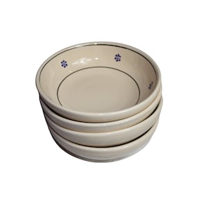 Puede incluir: Cuatro cuencos de cerámica apilables con un esmalte de color crema y un diseño floral azul y verde.