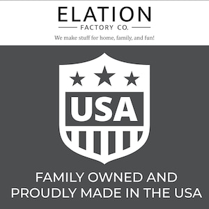 May include: White shield with three stars and the word "USA" inside. The shield is on a dark gray background with the text "FAMILY OWNED AND PROUDLY MADE IN THE USA" below it.