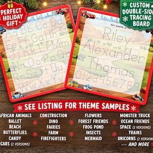 May include: Two red-framed custom double-sided tracing boards featuring a race track background. One board displays the alphabet in dotted letters, while the other shows the name Riley Alexander Thomas and numbers 0-9 in dotted font.