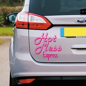 May include: A silver car with a pink vinyl sticker that says "Hot Mess Express" on the back. The sticker is in a retro font style.
