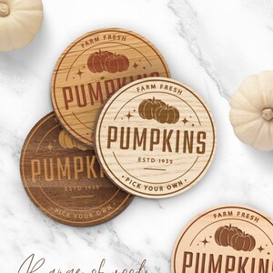 May include: Three round wooden signs with a rustic wood grain finish. Each sign features a brown pumpkin design with the text "FARM FRESH PUMPKINS ESTD 1932 PICK YOUR OWN."