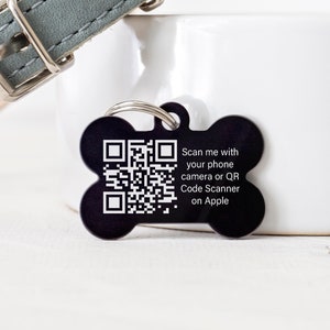 May include: Black bone-shaped dog tag with a white QR code and the text "Scan me with your phone camera or QR Code Scanner on Apple".