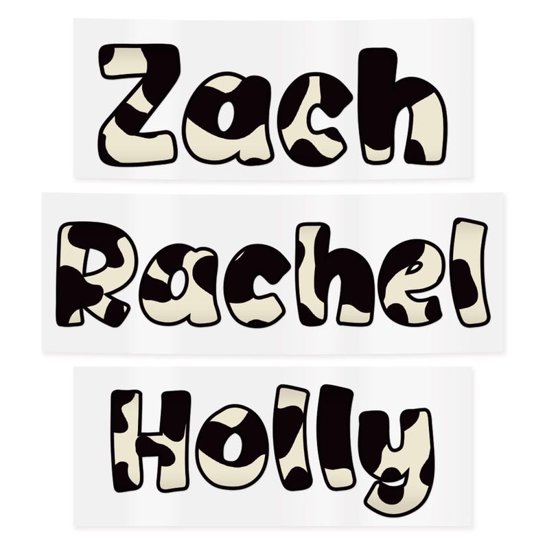 May include: Three rectangular stickers with names: "Zach", "Rachel", and "Holly". Each name is written in a bold, playful font with a black and white cow print pattern. The stickers are on a white background.